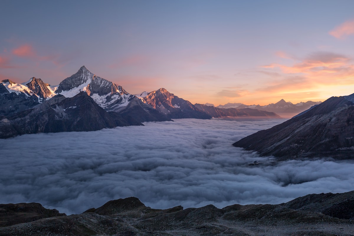 Alpine peaks rising above a sea of clouds at sunrise